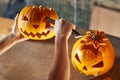 Woman carving Halloween pumpikn; Festive lifestyle concept