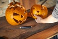 Woman carving Halloween pumpikn; Halloween pumpkin with a carved face