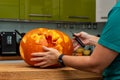 Woman carving a minion into a halloween pumpkin in the kitchen