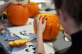 Woman carving pumpkin or jack-o-lantern at home.