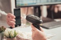 Woman cashier scanning qr code from buyer phone using barcode scanner. Man buying a gift in a female clothing store Royalty Free Stock Photo