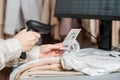 Woman cashier, seller scanning and reading  barcode from clothes using barcode scanner in female clothing store. Royalty Free Stock Photo