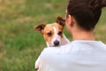 Woman in casual clothes hugging her favorite fluffy trained purebred Jack Russel Terrier dog outdoors in the nature on green grass Royalty Free Stock Photo