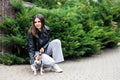 Woman in casual jacket sitting near her favorite fluffy trained purebred Jack Russell Terrier dog dressed in suit for dogs in the Royalty Free Stock Photo