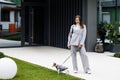 Woman in casual jacket standing with her favorite fluffy trained purebred Jack Russell Terrier dog dressed in suit for dogs near Royalty Free Stock Photo