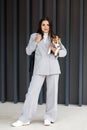 Woman in casual jacket standing with her favorite fluffy trained purebred Jack Russell Terrier dog dressed in suit for dogs near Royalty Free Stock Photo