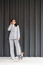 Woman in casual jacket standing with her favorite fluffy trained purebred Jack Russell Terrier dog dressed in suit for dogs near Royalty Free Stock Photo