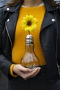 Woman catching a light bulb with a yellow flower