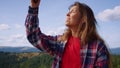 Woman catching mobile signal in mountains. Girl jumping in air with smartphone
