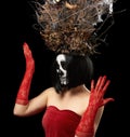 Woman of Caucasian appearance with skeleton make-up stands in a red velor dress with a large crown