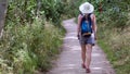 Woman, caucasian beauty style, blonde girl backpacking on a path through the forest.