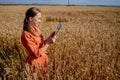 Woman caucasian technologist agronomist with tablet computer in the field of wheat checking quality and growth of crops for