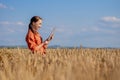 Woman caucasian technologist agronomist with tablet computer in the field of wheat checking quality and growth of crops for