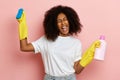 Woman celebrates the end of cleaning, she wears yellow cleaning gloves and holds blue brush