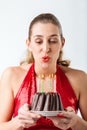 Woman celebrating birthday with cake blowing candles out Royalty Free Stock Photo