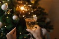 Woman celebrating with fireworks and champagne glass against christmas tree lights. Happy New Year Royalty Free Stock Photo