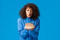 Woman celebrating her birthday on winter in family circle. Cute and happy african-american girl holding cake and blowing Royalty Free Stock Photo