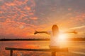 Woman Celebration Success Happiness Relaxed on a Wooden Evening Sky Sunset at the Lake Background, Sport and active life Concept Royalty Free Stock Photo