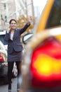 Woman on Cell Phone Hailing a Yellow Taxi Cab Royalty Free Stock Photo