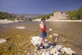 Woman on cell phone at the River Gard and the Pont du Gard, Nimes, France