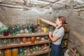 A woman in a cellar with food prepares supplies for the winter Royalty Free Stock Photo