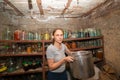 A woman in a cellar with food prepares supplies for the winter Royalty Free Stock Photo