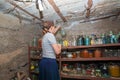 The woman in the cellar is gray-haired, the girl prepares food for the winter, canned food in glass jars on the rack Royalty Free Stock Photo