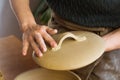 Woman ceramist attaching handle to the pot lid in pottery class. Potter workshop in ceramic studio Royalty Free Stock Photo