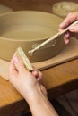Woman ceramist attaching handle to the pot in pottery class. Potter workshop in ceramic studio Royalty Free Stock Photo