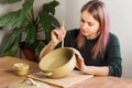 Woman ceramist attaching handle to the pot in pottery class. Potter workshop in ceramic studio Royalty Free Stock Photo