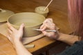 Woman ceramist attaching handle to the pot in pottery class. Potter workshop in ceramic studio Royalty Free Stock Photo