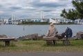 A Woman on a chair sitting alone. Bridge and Lake background.