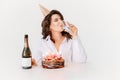 a woman with champagne and a birthday cake with candles.