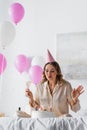 Woman with champagne blowing out candles