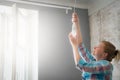 A woman changes the lamp in the pendant lamp