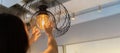 Woman changing light bulb in hanging lamp at home, house owner cleaning or changing vintage light bulb Royalty Free Stock Photo