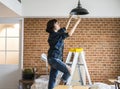 Woman changing lightbulb in her room Royalty Free Stock Photo