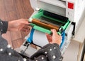 Woman changing the ribbon on photographic printer