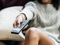 Woman changing TV channel with remote controller Royalty Free Stock Photo