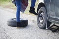 Woman changing a wheel on a car on the empty road Royalty Free Stock Photo