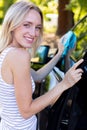 woman changing windscreen wipers on car