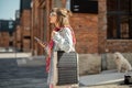 Woman charge phone from portable solar panel while walking outdoors