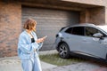 Woman charges her electric car near a house Royalty Free Stock Photo