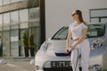 Woman charging electro car at the electric gas station