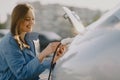 Woman charging electro car at the electric gas station