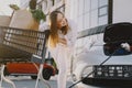 Woman charging electro car at the electric gas station