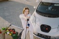 Woman charging electro car at the electric gas station