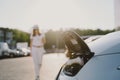 Woman charging electro car at the electric gas station