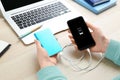 Woman charging mobile phone with power bank at table, closeup Royalty Free Stock Photo