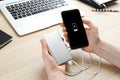 Woman charging mobile phone with power bank at table, closeup Royalty Free Stock Photo